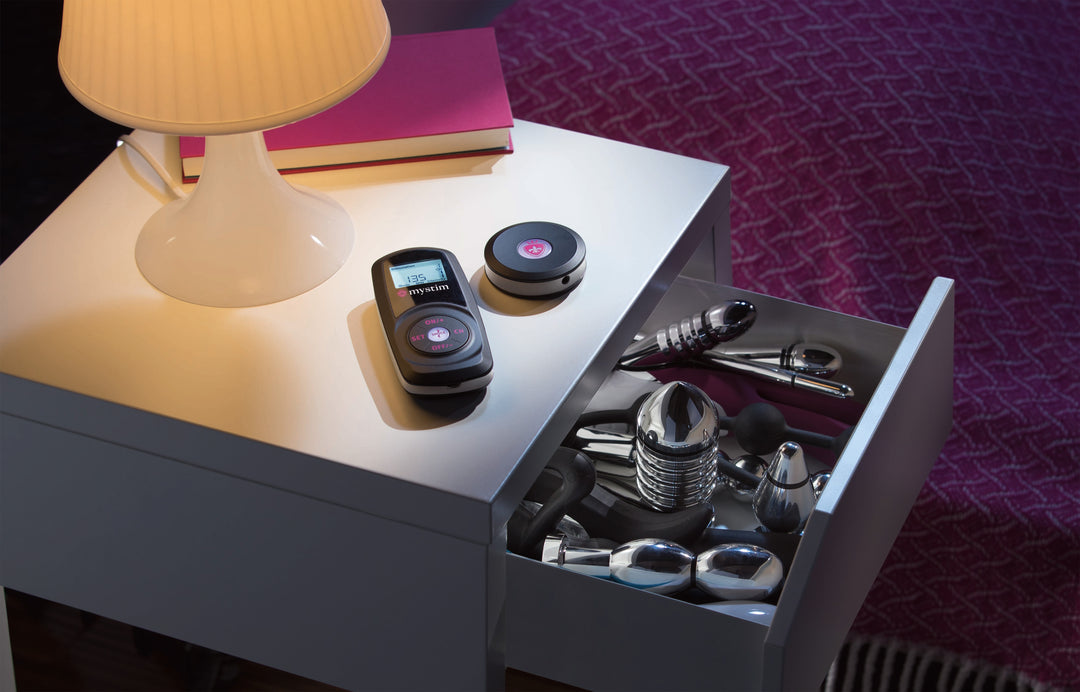 Promo Mystim Powerbox Cluster Buster Sultry Sub auf Nachttisch mit Schublade voller E-Stim Toys